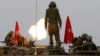 FILE - Israeli soldiers stand on an armored personnel carrier (APC) outside the central Gaza Strip as they fire mortar shell towards Gaza before a ceasefire was due, early Aug. 1, 2014. 
