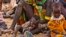 FILE - Women and their children wait to receive relief food supplies near the Kakuma Refugee Camp, northwest of Kenya's capital Nairobi, August 8, 2011. Aid agencies and the Kenyan government set up a new settlement for refugees about 30 kilometers away, in the northwestern town of Kalobeyei, last year.