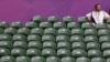 A spectator sits amid empty seats at the All England Lawn Tennis Club during a match at the London 2012 Olympics Games July 28, 2012. 