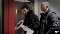 Le membre de l'association "Survie", Thomas Borrel, à gauche, et le chercheur François Graner arrivent à l'Institut François Mitterrand pour laisser une clé en bois symbolisant leur demande d'accès aux archives sur le Rwanda conflit, à Paris, France, 13 d