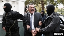 FILE - Extreme-right Golden Dawn party senior lawmaker Christos Pappas is escorted by anti-terrorism police officers to a courthouse in Athens, Oct. 3, 2013.