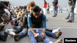 Migrants rest after disembarking from the British assault ship HMS Bulwark at the Sicilian port of Catania after being rescued at sea, Italy, June 8, 2015.