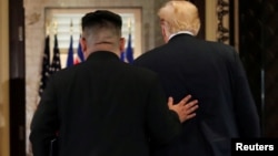 U.S. President Donald Trump and North Korea's leader Kim Jong Un leave after signing documents that acknowledge the progress of the talks and pledge to keep momentum going.