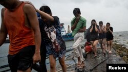 Residents prepare to return to their homes after volunteers and local officials reminded the neighborhood to evacuate, in preparation for Super Typhoon Noru, in Manila, Philippines, Sept. 25, 2022. 