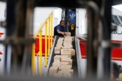 Bahraini officials load medical aid and ground-support equipment into a plane as they head to Beirut to provide support following Tuesday's blast, at Isa Air Base in Ras Al Bur, Bahrain, Aug. 7, 2020.