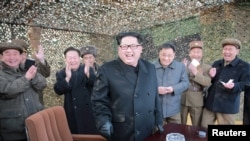 North Korean leader Kim Jong Un (C) smiles as he guides a test fire of a new multiple launch rocket system in this undated photo released by North Korea's Korean Central News Agency (KCNA) in Pyongyang March 4, 2016. 
