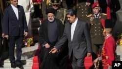 El presidente de Irán, Ebrahim Raisi, en el centro a la izquierda, camina con el presidente de Venezuela, Nicolás Maduro, cuando llega al palacio presidencial de Miraflores en Caracas, Venezuela, el lunes 12 de junio de 2023.
