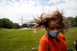 FILE - Marine One arrives on the White House South Lawn as CBS journalist Paula Reid and others prepare for President Donald Trump to board the presidential helicopter, May 14, 2020, in Washington.