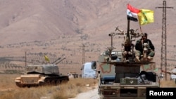 Hezbollah and Syrian flags flutter on a military vehicle in Western Qalamoun, Syria, Aug, 28, 2017.
