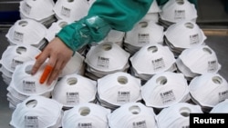 FILE - Masks are seen on a production line manufacturing masks at a factory in Shanghai, China January 31, 2020.