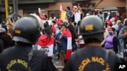People celebrate in the street after Peru's new interim President Francisco Sagasti was designated by Congress to lead the nation, in Lima, Peru, Nov. 16, 2020. 