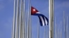 FILE - The Cuban flag flies in front of the U.S. Interests Section, background, in Havana, May 22, 2015. 