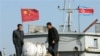 FILE - North Korean men stand on a boat used for trade between China and North Korea on the waterfront at the North Korean town of Sinuiju, opposite the Chinese border city of Dandong, Oct. 11, 2006.