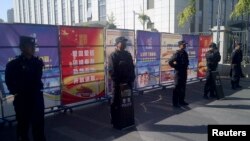 Policemen in riot gear guard a checkpoint on a road near a courthouse where ethnic Uighur academic Ilham Tohti's trial is taking place in Urumqi, Xinjiang Uighur Autonomous Region, Sept. 17, 2014.