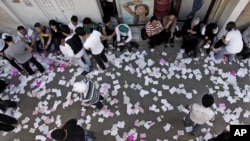 In this photo taken during a government-organized tour, Syrian campaign workers wait outside a polling station during the parliamentary elections, in Damascus, Syria, May 7, 2012.