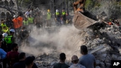 Rescue workers and volunteers search for victims under the rubble of a destroyed building hit in an Israeli airstrike, in Aalmat village, northern Lebanon, Nov. 10, 2024.