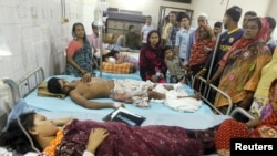 People who sustained injuries in a series of blasts are surrounded by their relatives at a hospital in Dhaka, Oct. 24, 2015.