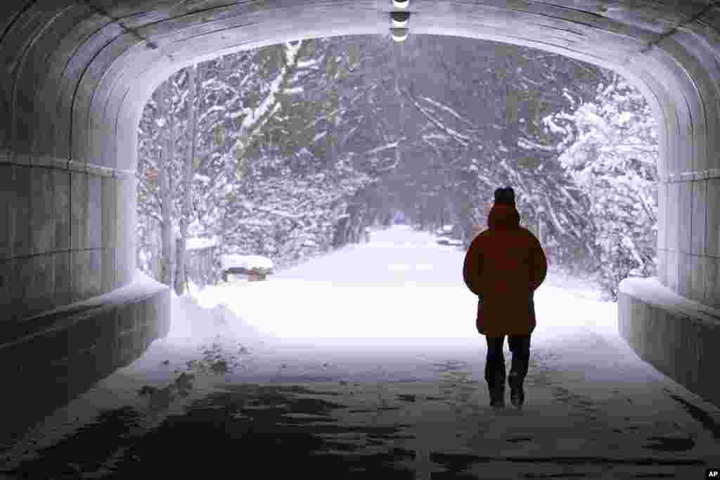A pedestrian walks though a tunnel along the snow-covered Monon Trail in Carmel, Indiana, Jan. 6, 2025.