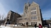 FILE - Students walk on the Boston College campus, Feb. 17, 2021.