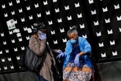 People seen along along 53rd Street wear personal protective equipment during the global outbreak of coronavirus disease (COVID-19) in Chicago, Illinois, U.S. April 7, 2020. REUTERS/Joshua Lott