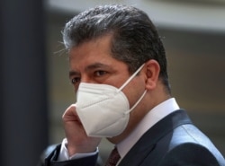 FILE - Prime Minister of the Regional Government of Iraqi Kurdistan Masrour Barzani adjusts his protective mask as he waits for the arrival of Iraqi Prime Minister in Irbil, the capital of the northern Iraqi Kurdish autonomous region, Sept. 10, 2020.