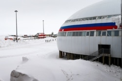 FILE - A group of soldiers stand near the "Arctic Trefoil" on the Alexandra Land island near Nagurskoye, Russia, May 17, 2021. Once a desolate home mostly to polar bears, it now houses Russia's northernmost military outpost.