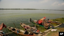 A Kashmiri fisherman cooks food inside his anchored boat on the shore of the Dal Lake in Srinagar, Indian controlled Kashmir, Oct. 2, 2019. 