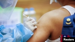 FILE - An army parliament member receives the AstraZeneca Covishield coronavirus disease vaccine ahead of the new parliament opening in Naypyitaw, Myanmar, Jan. 30, 2021.