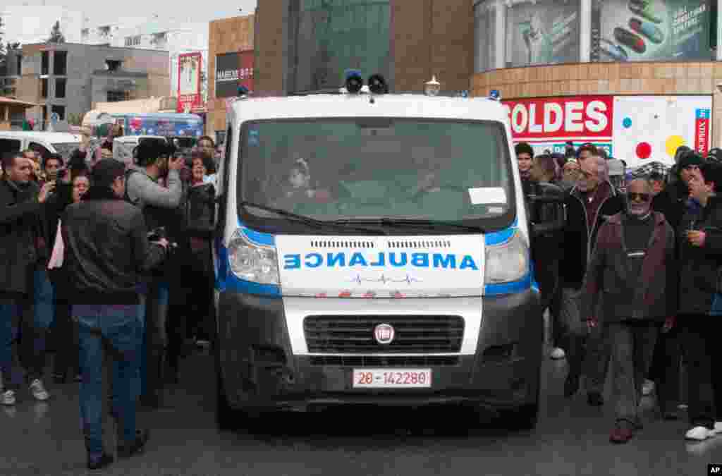 Tunisians accompany the ambulance carrying the body of opposition leader Chokri Belaid, from his home to his father's home, Tunis, Feb. 7, 2013.