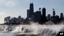 FILE - Ice forms as waves crash along the Lake Michigan shore in Chicago, Illinois, Jan. 27, 2014.