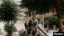 FILE - Members of the Islamist rebel group al-Nusra Front prepare a homemade mortar in the Bustan al-Qasr neighborhood of Aleppo, Syria, June 5, 2014. 