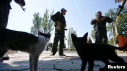 Pemberontak pro-Rusia berjaga-jaga di pos pemeriksaan di luar Donetsk 6 September 2014. 