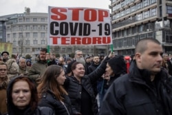 FILE - People take part in a protest against coronavirus vaccination and restrictions in Belgrade, Serbia, April 3, 2021.