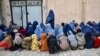 Afghan women and children wait to receive food aid from a local charity during the holy fasting month of Ramadan in Mazar-i-Sharif on March 5, 2025.