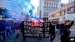 FILE - Demonstrators protest death of George Floyd, a handcuffed black man in police custory in Minneapolis, in Oakland Calif.