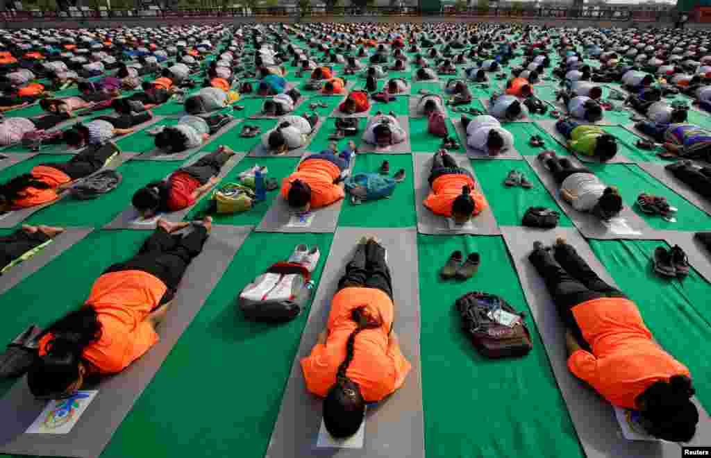 Orang-orang berlatih yoga selama sesi latihan sebelum penyelenggaraan Hari Yoga Internasional, di Lucknow, India.