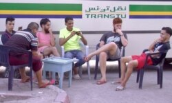 Young men are seen at a bus stop cafe in Tunis. Unemployment reaches 30 percent in some parts of Tunisia. (L. Bryant/VOA)