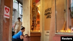 Katy D'Aquino and her husband, Jason, board up their gallery Fawkes Fine Art for the eighth time since the beginning of the pandemic, as Hurricane Zeta approaches the Gulf Coast in New Orleans, Louisiana, Oct. 28, 2020. 