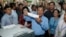 In this Sunday, July 29, 2018, file photo, Cambodian Prime Minister Hun Sen, center, of the Cambodian People's Party (CPP), holds a ballot before voting at a polling station in Takhmua in Kandal province, southeast of Phnom Penh, Cambodia. 