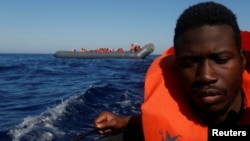 A migrant reacts after being rescued from a rubber dinghy by the Malta-based NGO Migrant Offshore Aid Station (MOAS) in the central Mediterranean in international waters some 15 nautical miles off the coast of Zawiya in Libya, April 14, 2017. 