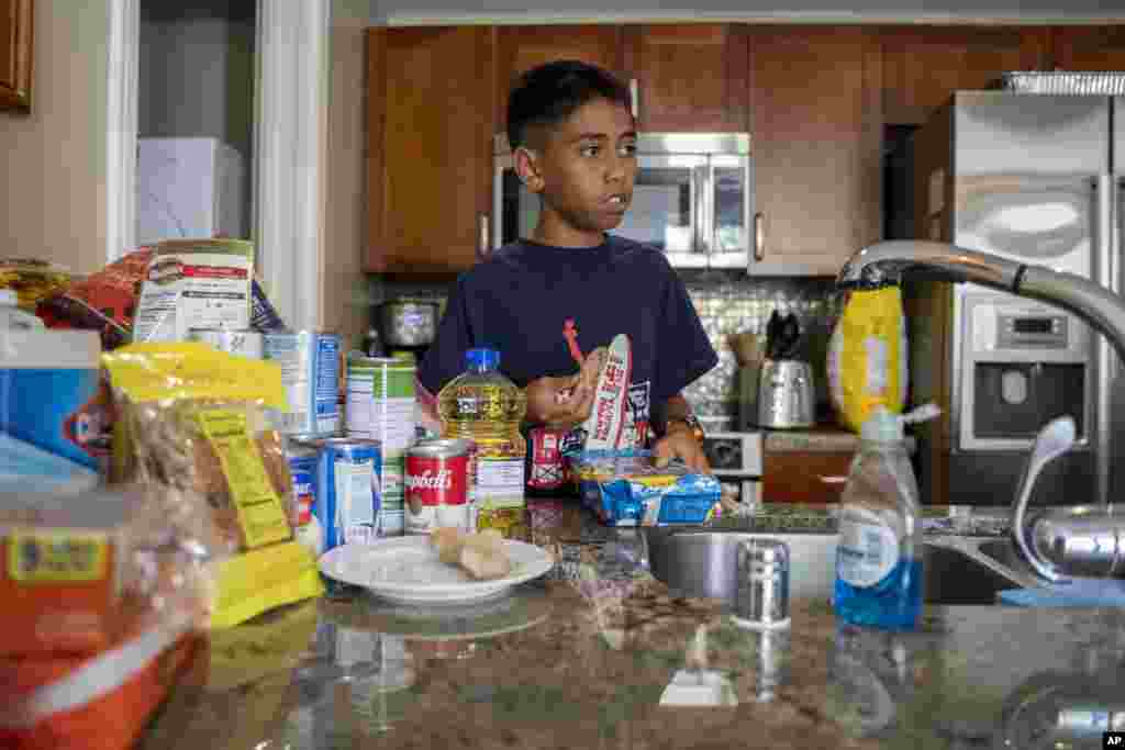Puʻuwai Nahoʻoikaika takes some cookies as he listens to his mother during an interview on Oct. 3, 2023, in Lahaina, Hawaii.