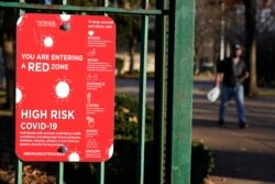 ARCHIVO - Un aviso a la entrada de un parque advierte a los peatones del creciente riesgo del coronavirus, en el sector Ironbound de Newark, New Jersey, el martes 24 de noviembre de 2020.