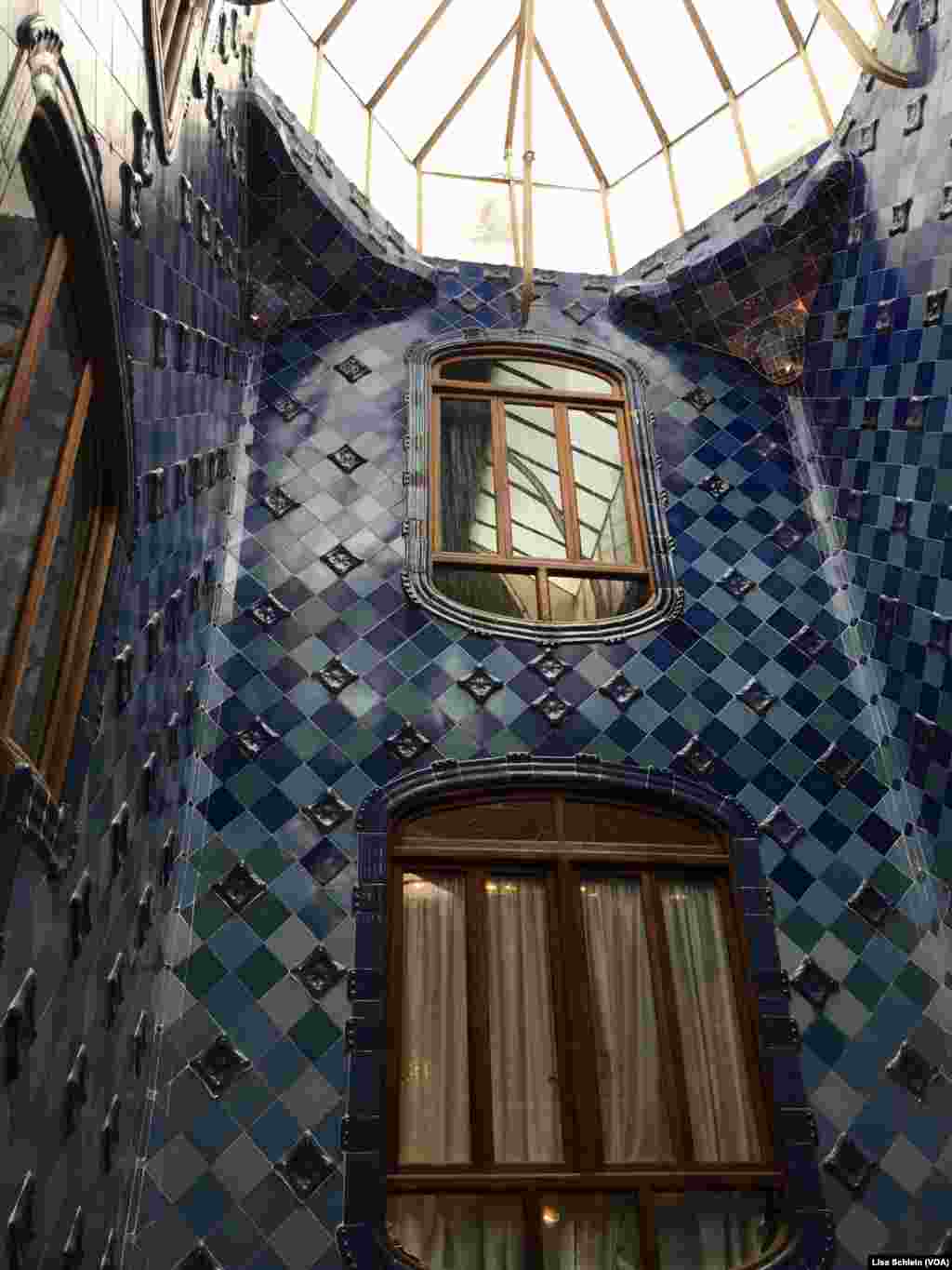 A large skylight illuminates the dark blue tiles of the upper floor of Casa Batllo, in Barcelona.