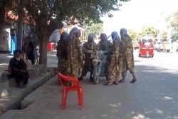 In this picture taken on Aug. 9, 2021, Taliban fighters stand along a road in the northern city of Kunduz that was captured by the Taliban over the weekend.