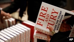 FILE - A customer looks at a copy of Michael Wolff's 'Fire and Fury: Inside the Trump White House' as they go on sale at a bookshop, in London, Jan. 9, 2018. 