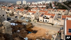 Palestinian men work at a construction site in the West Bank Jewish settlement of Ariel, Jan. 25, 2017.