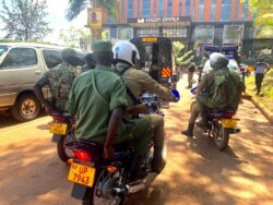 Security officers leave the Media Center where journalists walked out of a security presser in protest of security brutality in Kampala, Dec. 28, 2010. (Halima Athumani/VOA)