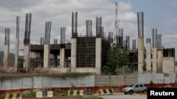 Commuters drive past the construction site by Odebrecht of the Caracas, the Guatire metro rail project in Guatire, Venezuela, March 28, 2017. Odebrecht left at least 23 multi-million dollar projects unfinished or stalled in Venezuela.