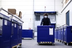 An employee of Cryonomic, a Belgium company producing dry ice machines and containers which will be used for COVID-19 vaccine transportation, pushes a medical dry ice container in Ghent, Dec. 2, 2020.