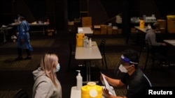 Nurse immuniser Jude Mendoza prepares patient Phiyona Castillo to receive the AstraZeneca vaccine at a COVID-19 vaccination clinic at the Bankstown Sports Club as the city experiences an extended lockdown, in Sydney, Australia, Aug. 3, 2021.